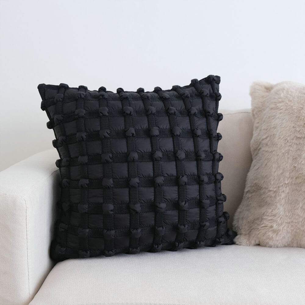 Luxury decorative checkered cushion for lumbar support on sofa at home.